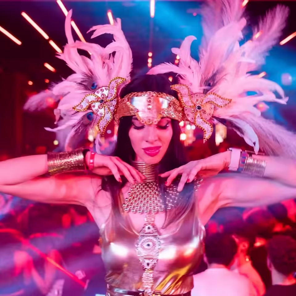 Performer Queen’s Angels con un costume scenografico e piume rosa